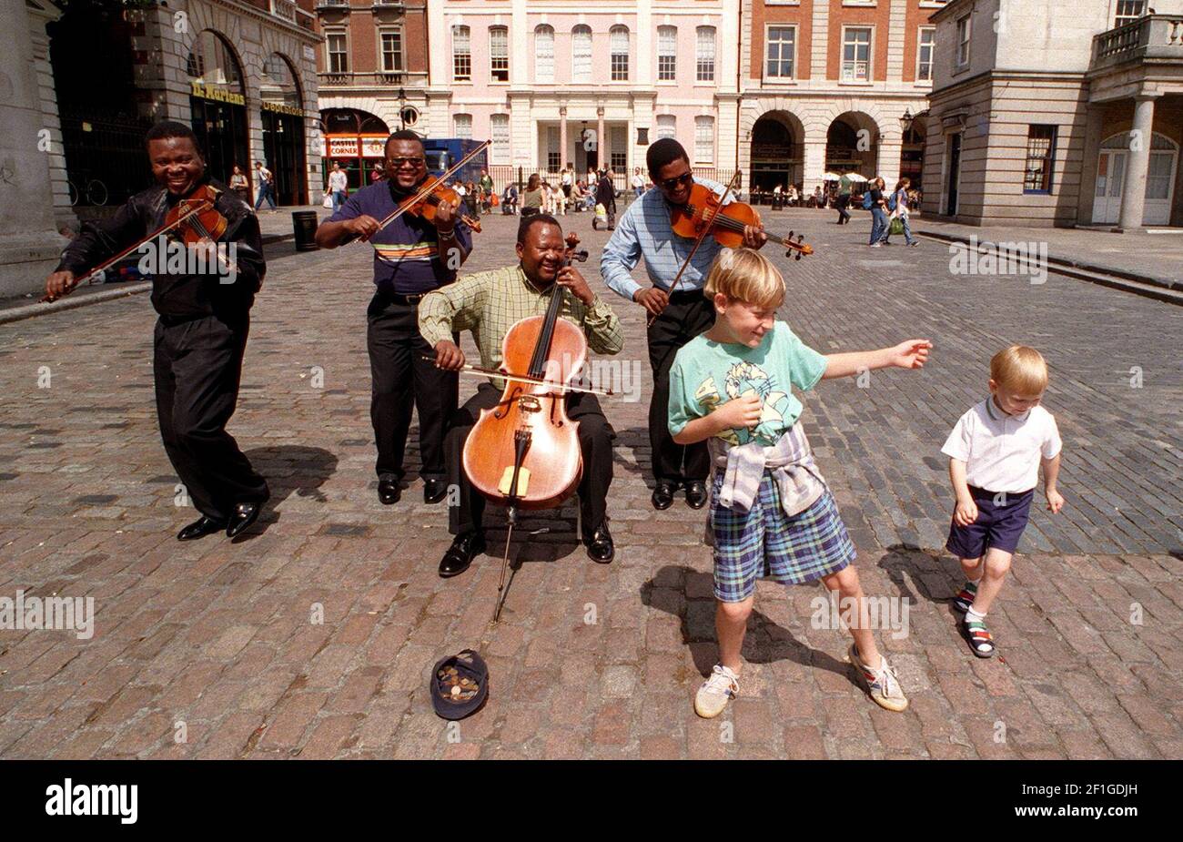 Soweteo Streichquartett spielt heute in Covent Garden zur Unterstützung der christlichen Hilfe. Kinder tanzen zur Musik Stockfoto