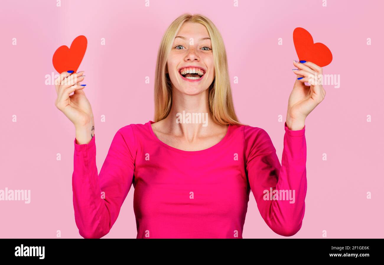 Valentinstag. Glückliches Mädchen am Valentinstag mit Herzen. Lächelnde Frau mit rotem Herzen. Liebeskonzept. Stockfoto
