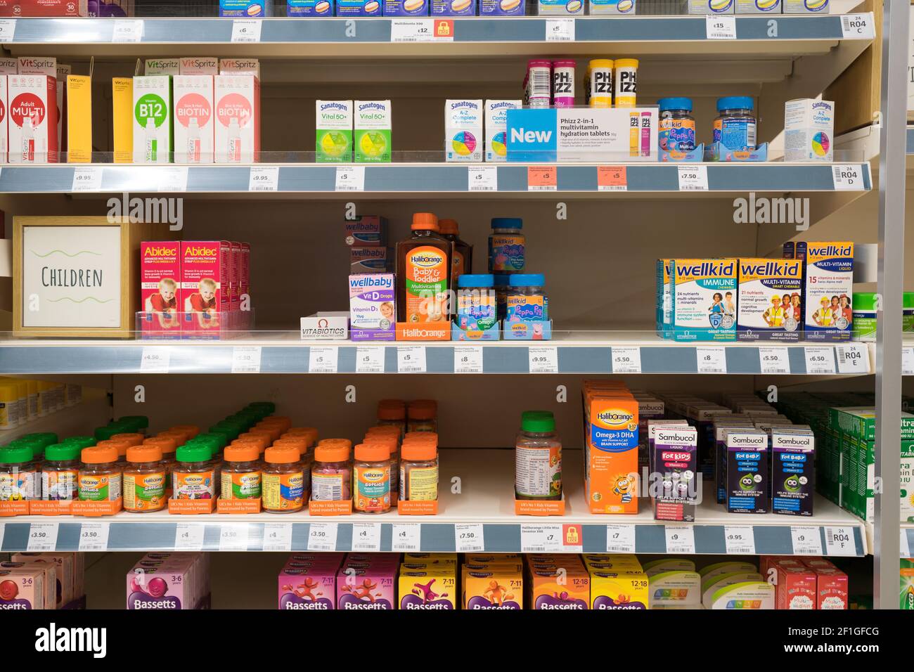 Die Komplementärmedizin von Multivitaminen und Zusatzarzneimitteln für Kinder wird in den Regalen zum Verkauf in Sainsbury's Supermarkt, Großbritannien, ausgestellt Stockfoto