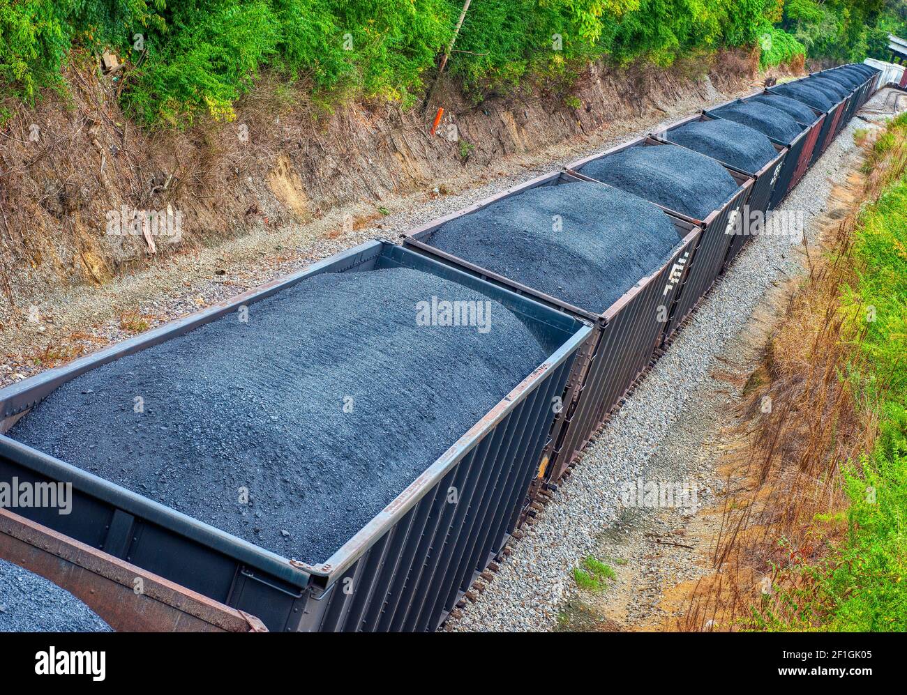 Horizontale Aufnahme einer Linie von Kohlewagen auf einem langen Güterzug. Dies ist ein überarbeitetes Bild. Stockfoto