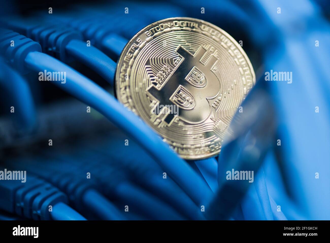 Glänzende Bitcoin simbol in blauen Kabeln Nahaufnahme. Kryptowährung, digitales Curency-Konzept Nahaufnahme Stockfoto