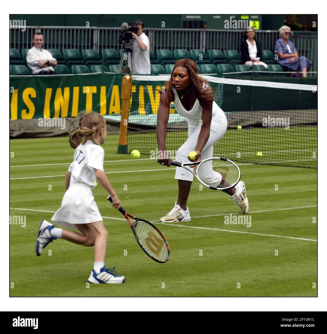 Venus und Serena Williams waren heute in Wimbledon, um ihr neues Buch "How to Play Tennis" zu veröffentlichen. Sie verbrachten einige Zeit damit, einigen jungen aufstrebenden britischen Spielern mit ihrem Spiel zu helfen.pic David Sandison 17/6/2004 Stockfoto