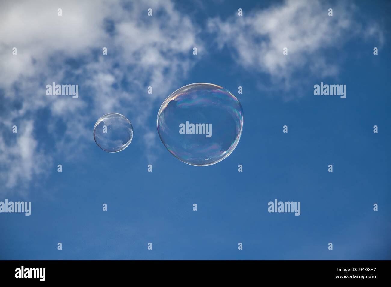 Große Seifenblasen am blauen Himmel mit einigen Wolken Stockfoto
