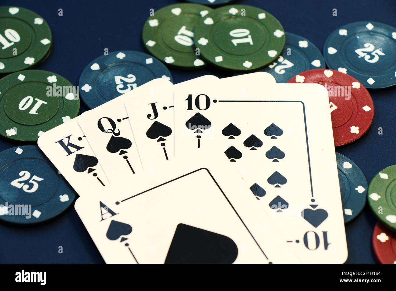 Eine Nahaufnahme von Royal Flush Karten von Kleeblätter und Chips verbreiten sich auf einem Pokertisch mit dem Ass in Die Mitte Stockfoto