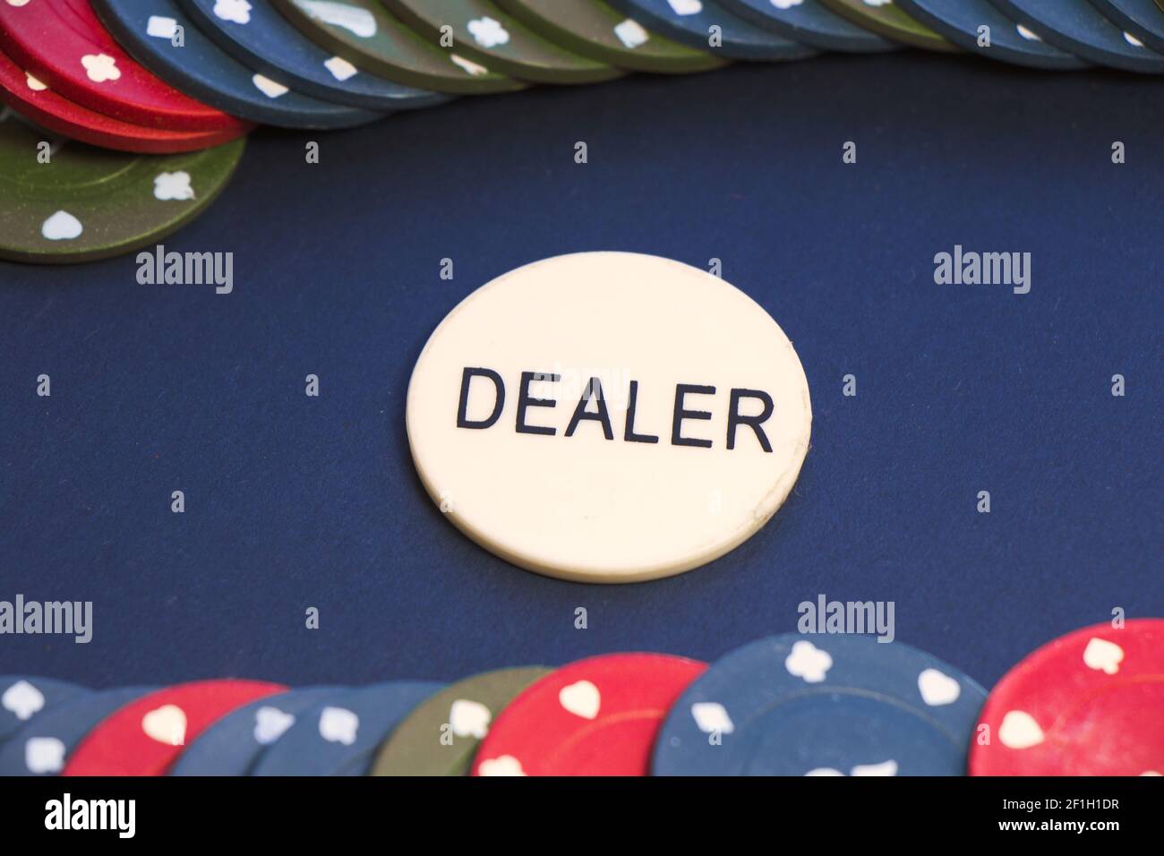 Ein Nahaufnahme von zwei Reihen von Poker-Chips mit Ein Dealer in der Mitte des Pokertisches Stockfoto