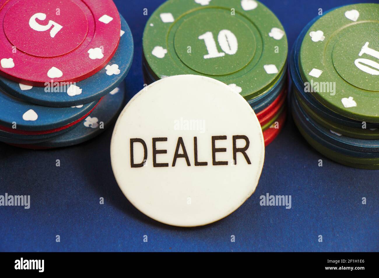 Ein Nahaufnahme von Poker-Chips mit einem Dealer in Die Mitte des Pokertisches Stockfoto