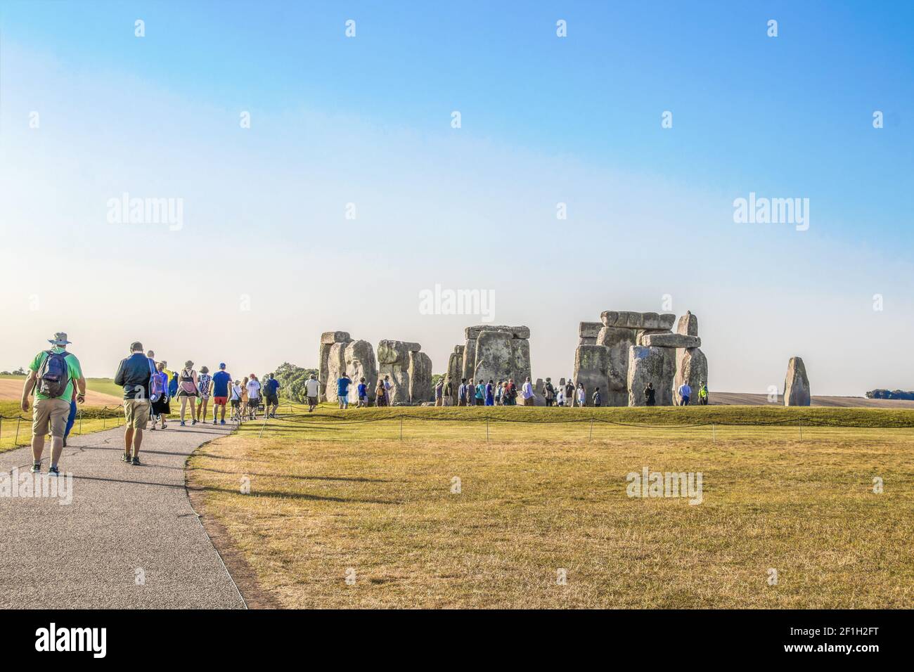 7-25-2019 Stonehenge UK - Touristen zu Fuß Pfad zu alten Stein Kreis in der Mitte eines Ebene- auf Heißester Tag in der englischen Geschichte - die meisten Taki Stockfoto