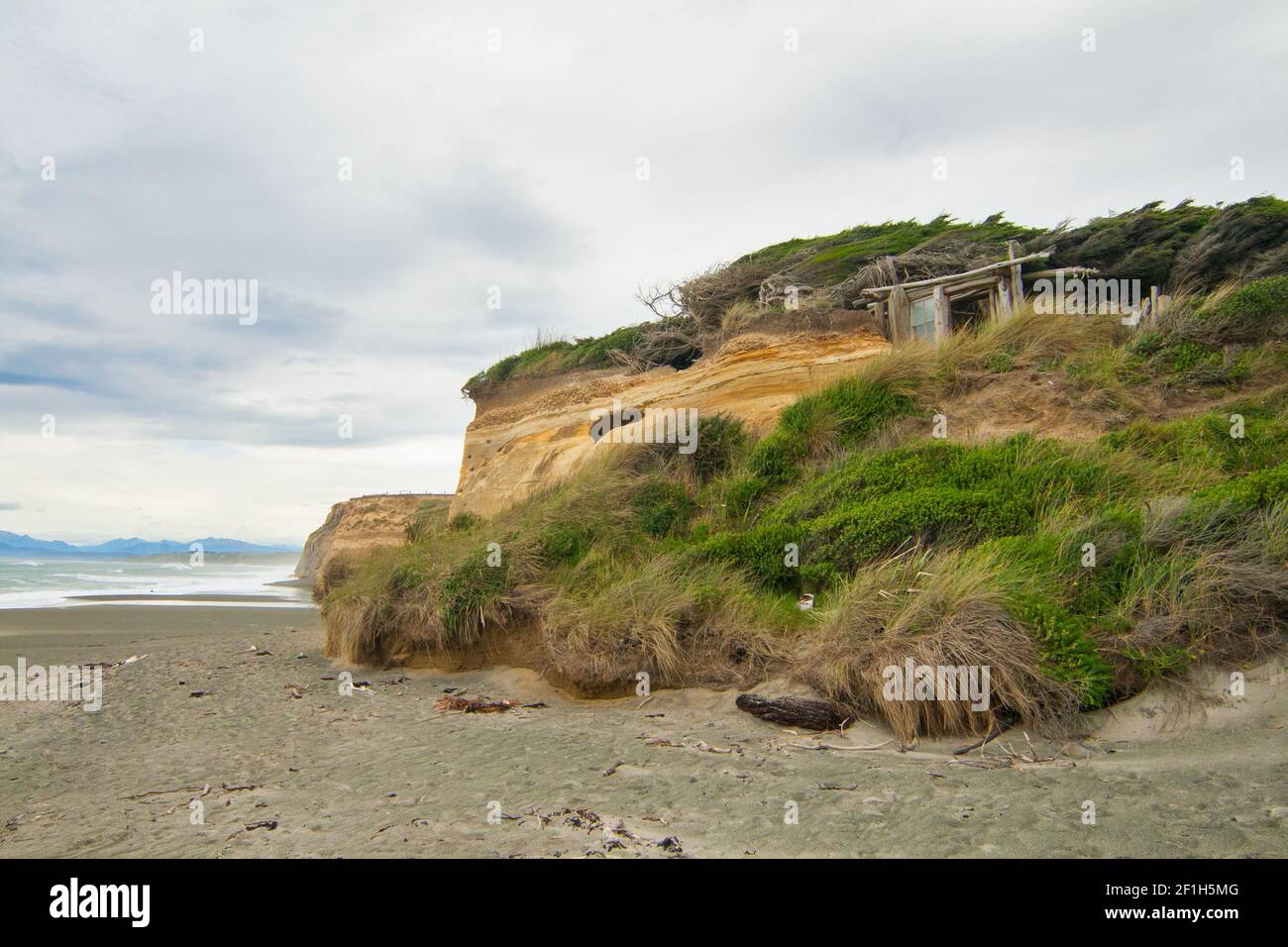 Verlassene hölzerne 'Shiloh's House' in erodierten Felsen von Gemstone Beach in der Nähe von Orepuki, Waewae Bay, Southland, Neuseeland Stockfoto