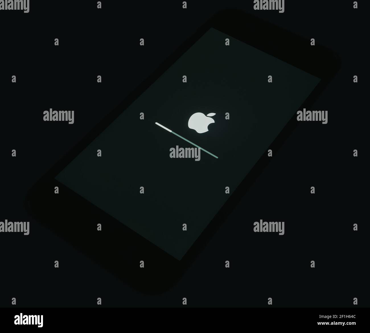 2020: IOS laden auf dem Apple iPhone Schwarzer Startbildschirm, isoliert in der Dunkelheit Stockfoto