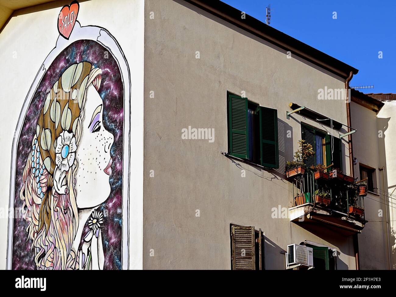 Blick auf ein Graffiti-Wandbild auf der Straße, das ein weibliches Gesicht auf einer Hauswand im Trullo-Viertel zeigt. Rom, Italien, Europa, EU Stockfoto