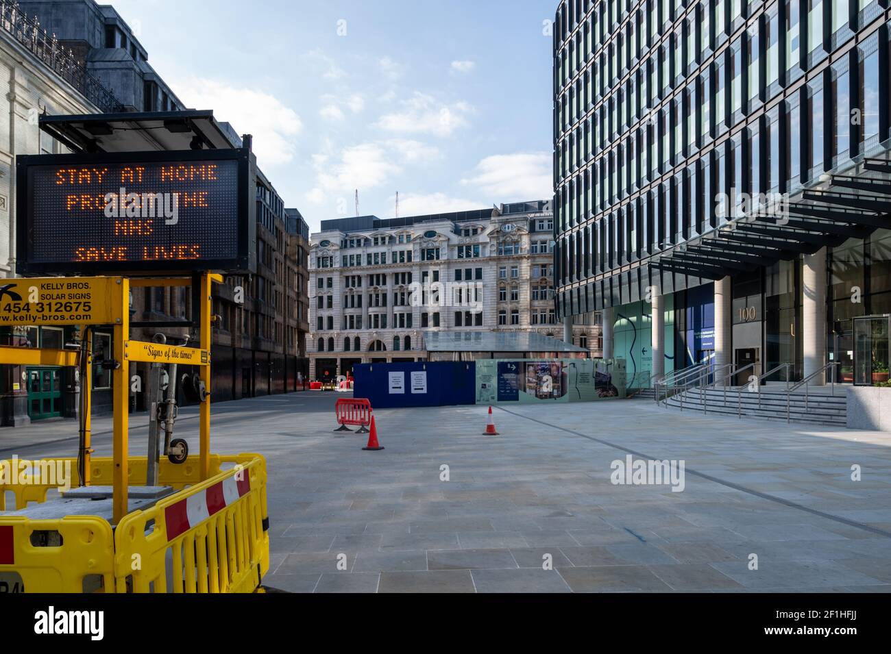 Liverpool Street, London. Covid-Pandemie, dritte Sperre. Ein beleuchtetes Display mit dem Titel „zu Hause bleiben, NHS schützen, Leben retten“ vor einer leeren Straße. Stockfoto
