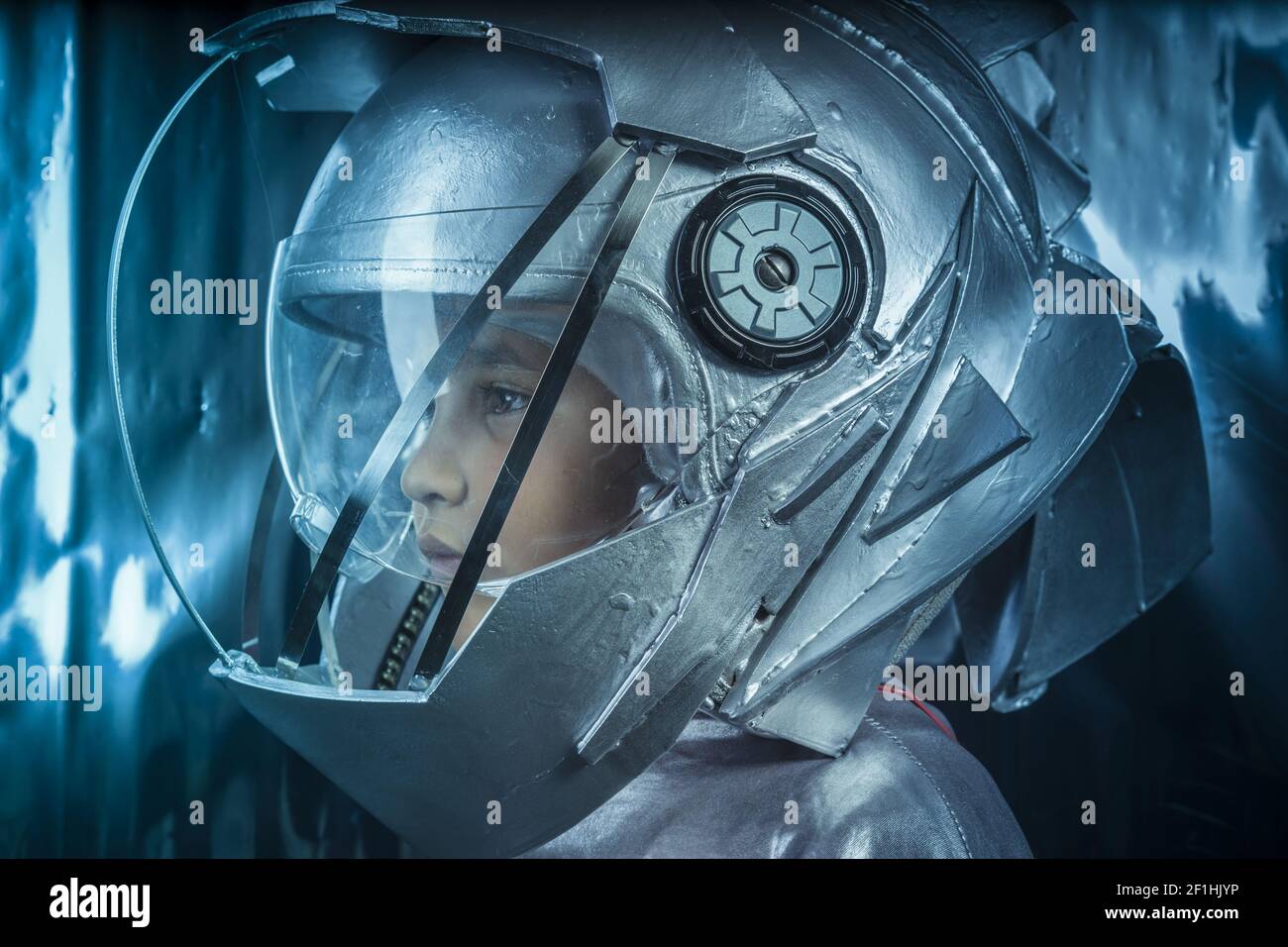 Stolz, junge spielen um ein Astronaut mit Weltraumhelm und Metall-Anzug Stockfoto