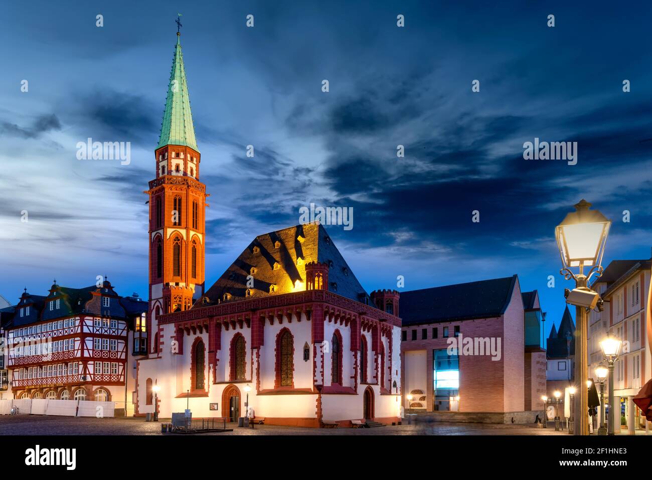 Römerberg mit Kirche in Frankfurt am Main mit beleuchteten Gebäuden Zur blauen Stunde Stockfoto