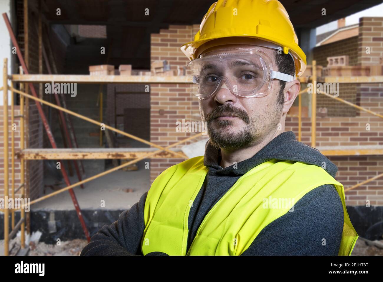 Ingenieur Do it yourself, Mann in Gelb builder Helm mit Schutzbrille bereit, mit den Bauarbeiten zu beginnen gekleidet Stockfoto