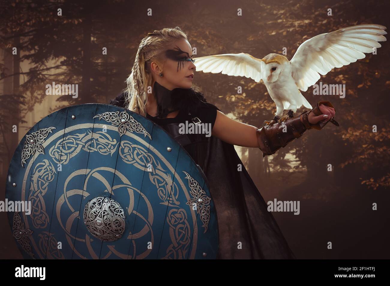 Krieger, schöne weiße Eule, Viking blonde Frau mit Schild und Schwert, Litzen im Haar. Stockfoto