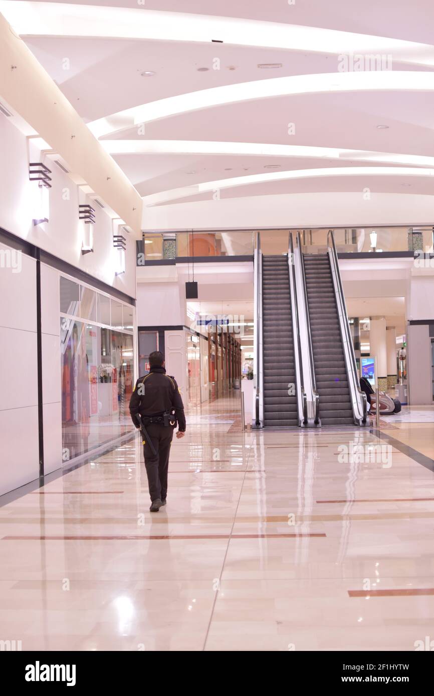 Sicherheitsmann, der in einem leeren Einkaufszentrum in Carcaixent, Valencia, Spanien, läuft. Stockfoto