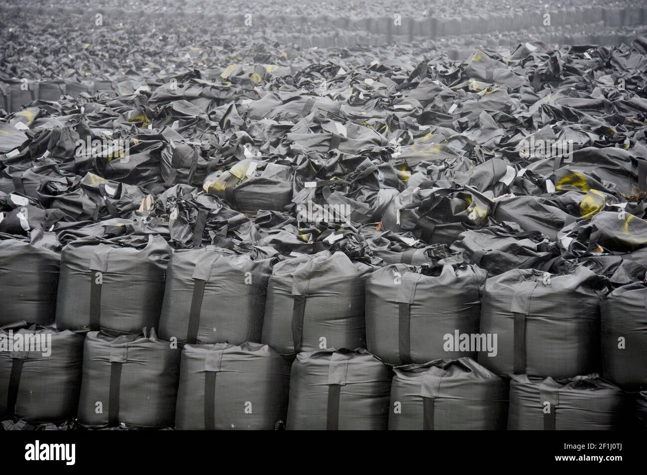 Das Foto zeigt Zehntausende Säcke mit radioaktiv verseuchten Böden und Unkraut, die im Juni 2013 auf einer temporären Lagerzone in der Nähe des Kernkraftwerks Fukushima Daiichi in Okuma, Präfektur Fukushima, Japan, gestapelt wurden. Heute gibt es Tausende dieser Deponien, die in der Präfektur verstreut sind, und die Dekontaminationsbemühungen sowie die Stilllegung des Atomkraftwerks gehen weiter. Fotograf: Robert Gilhooly Stockfoto