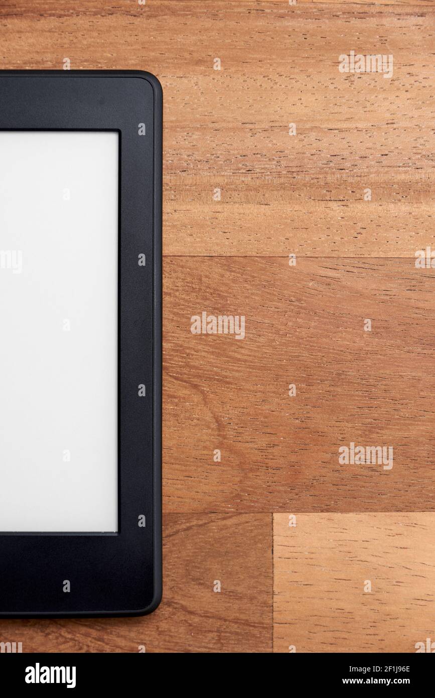 Nahaufnahme eines elektronischen Lesers mit leerem Bildschirm auf einer Holzfläche. Konzepte von Technologie und Moderne. Bild mit Kopierbereich. Stockfoto