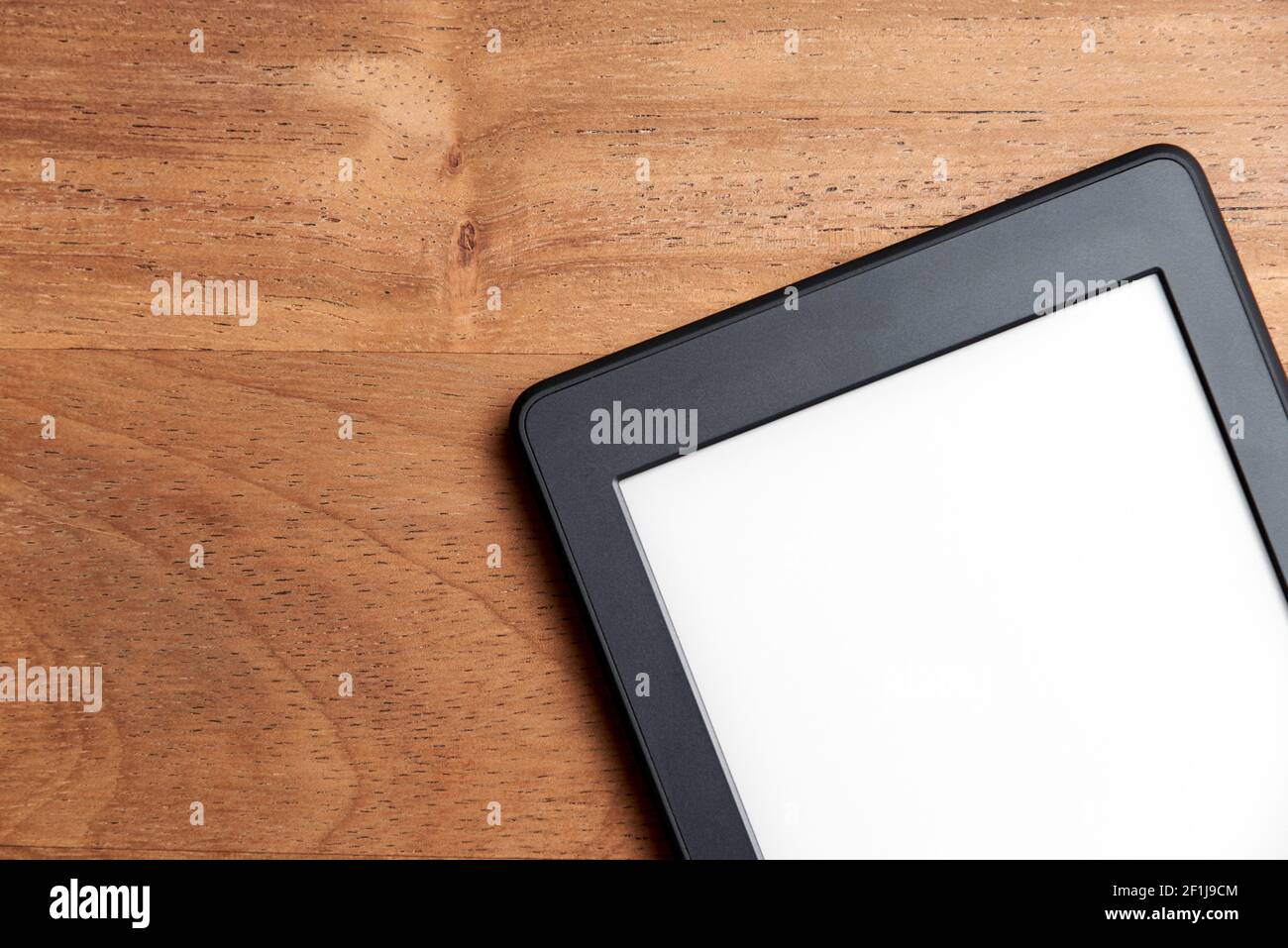 Nahaufnahme eines elektronischen Lesers mit leerem Bildschirm auf einer Holzfläche. Konzepte von Technologie und Moderne. Bild mit Kopierbereich. Stockfoto