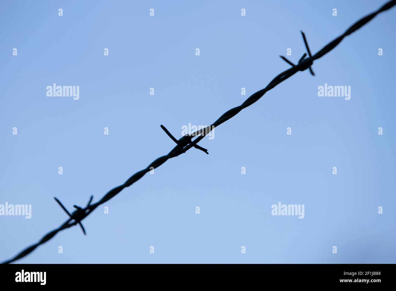 Nahaufnahme von drei Spitzen eines Stahldrahtes, blauer Himmel als Hintergrund Stockfoto