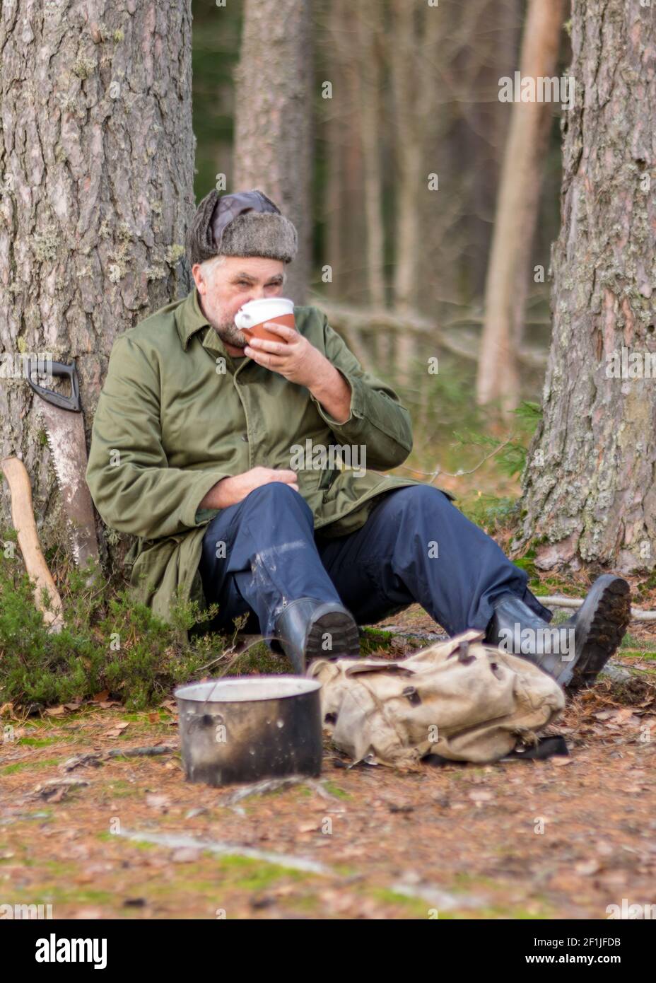 Ein Förster im Wald trinkt in Ruhe Tee, verschwommener Waldhintergrund ...