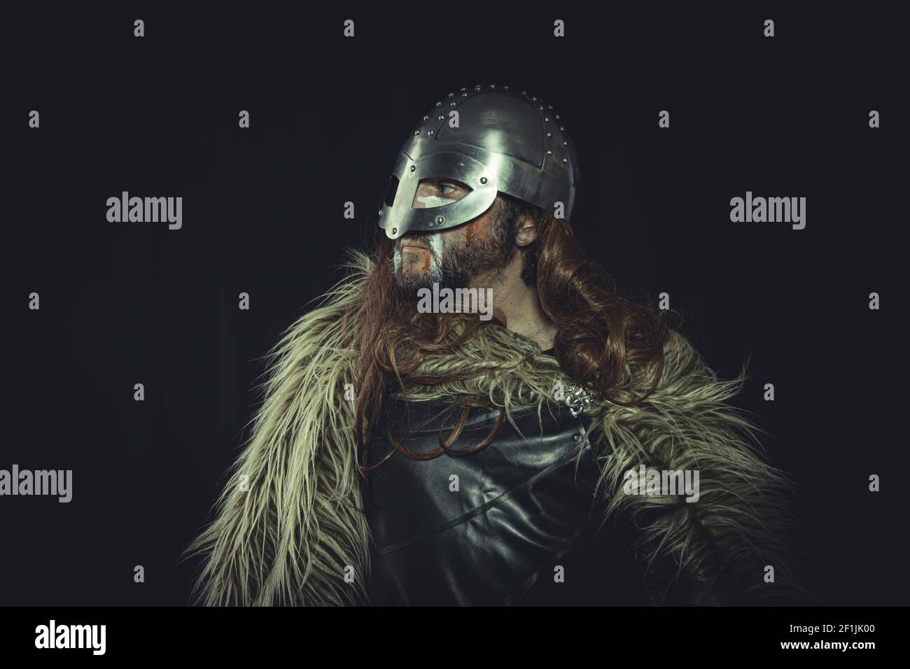 Viking, skandinavischer Krieger mit Helm und Kriegsbildern, trägt ein Schwert und einen Umhang aus Tierhaut Stockfoto