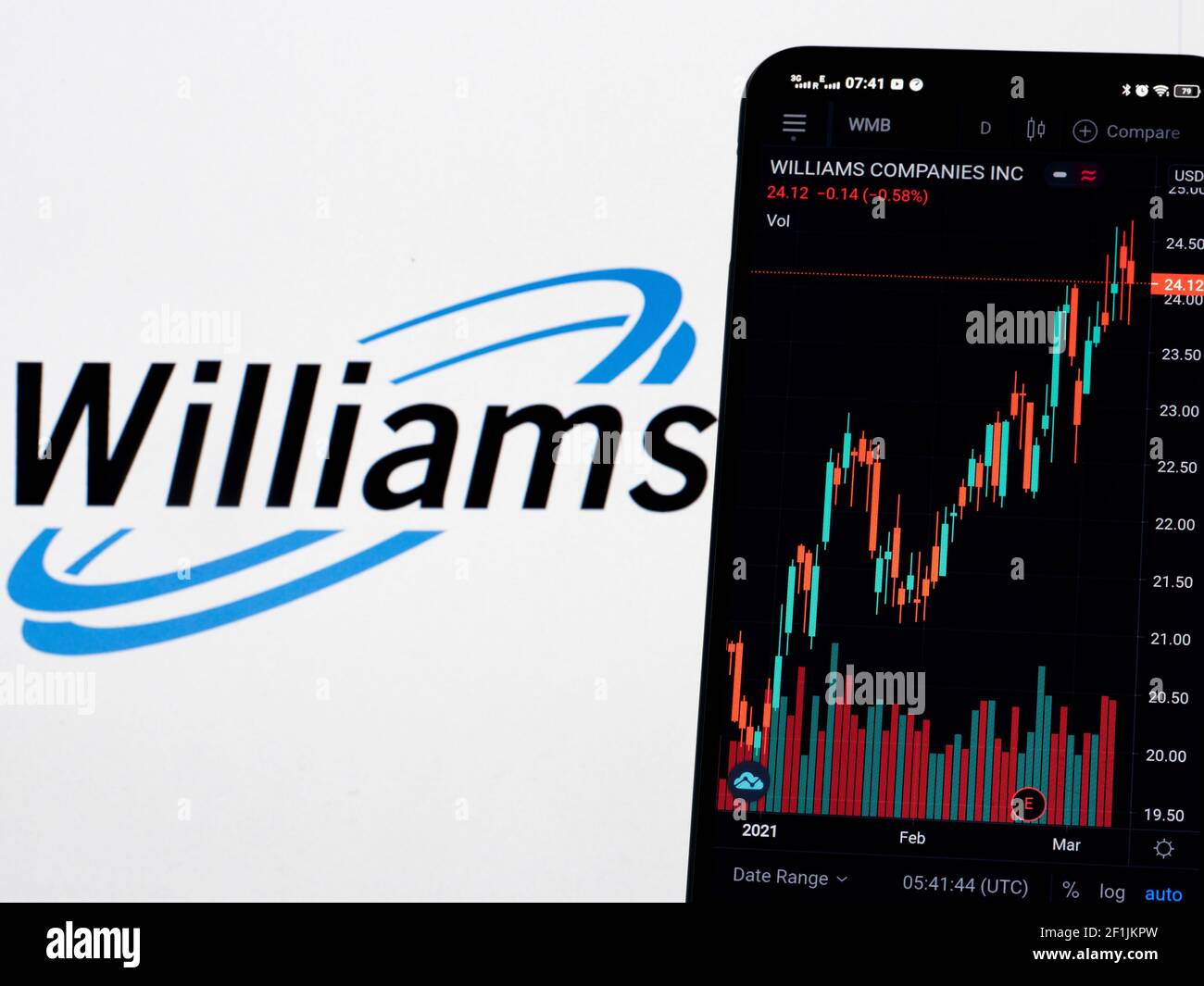 In dieser Abbildung werden die Börseninformationen von Williams Companies Inc. Auf einem Smartphone angezeigt, während das Logo von Williams Companies Inc. Als Hintergrund angezeigt wird Stockfoto