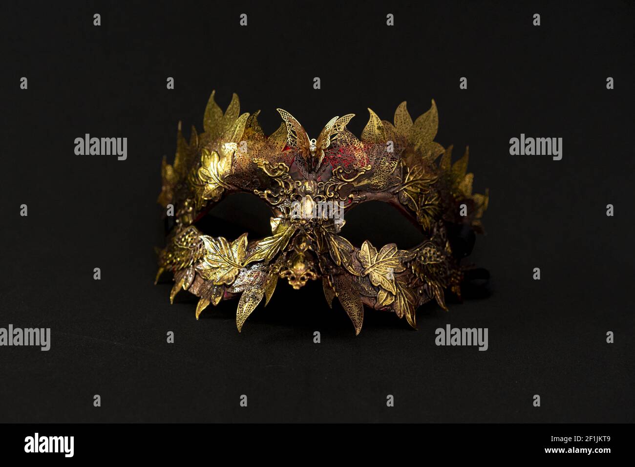 Cosplay, Venezianische Maske in Gold- und Rottönen mit metallischen Stücke in der Form der Blätter. originelles und einzigartiges Design, Kunsthandwerk Stockfoto