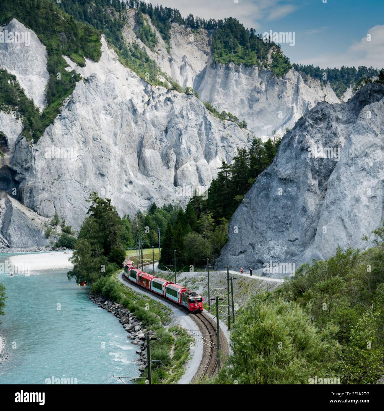 Wanderer und die Rhätische Bahn am Ufer des Rhein in der Ruinaulta-Schlucht Stockfoto