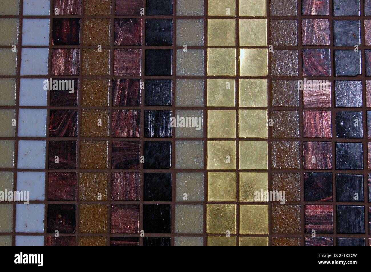 Ein Mosaik-Muster aus kleinen Quadraten in Streifen aus Gold, Bronze, braun, beige, creme und weiß platziert Stockfoto