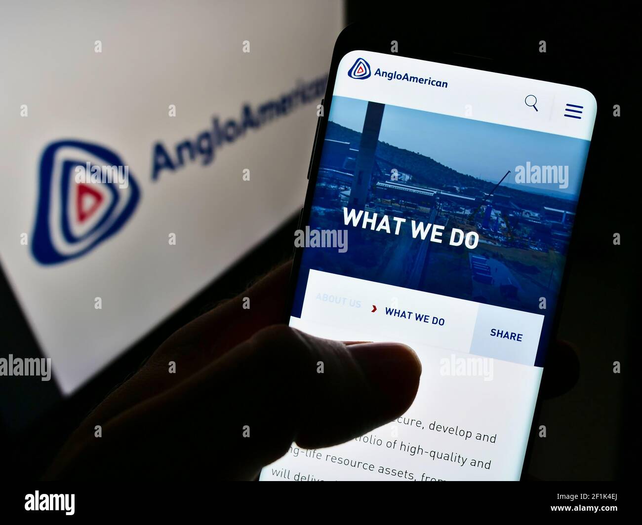 Person, die Mobiltelefon mit Website des globalen Metall- und Bergbauunternehmens Anglo American plc auf dem Bildschirm mit Logo hält. Fokus auf der Mitte des Telefondisplays. Stockfoto