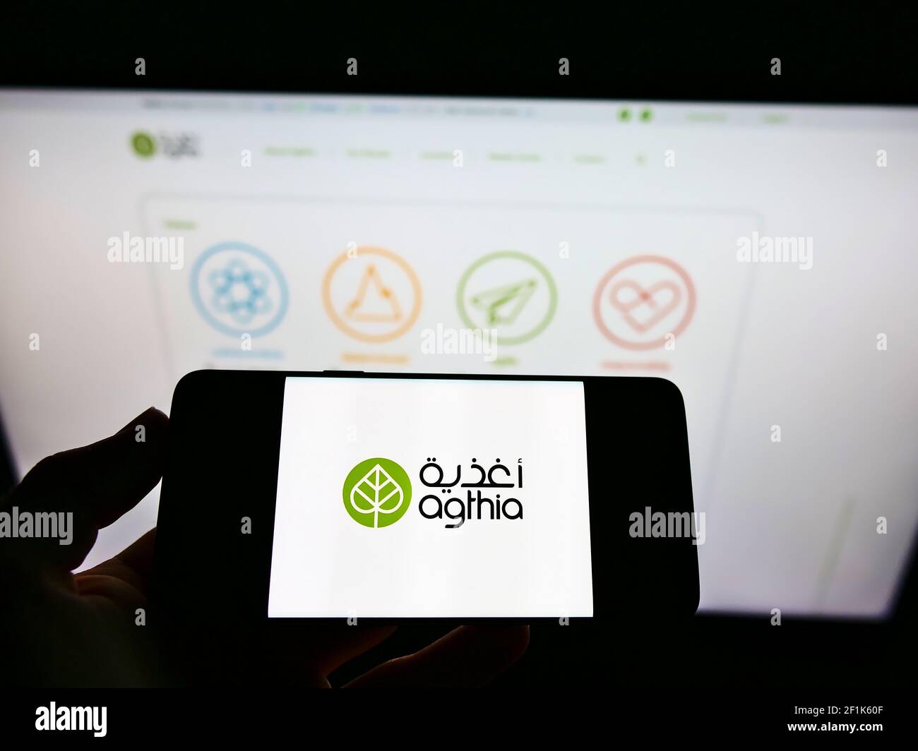 Person, die das Mobiltelefon mit dem Logo der Agthia Group PJSC (Abu Dhabi) auf dem Bildschirm vor der Webseite hält. Fokus auf Handy-Display. Stockfoto