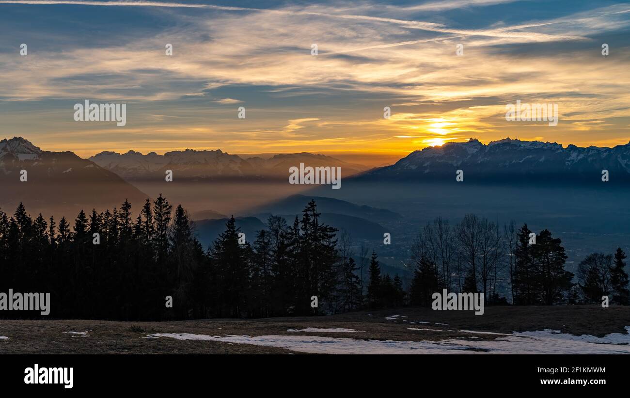 Toller Sonnenuntergang über dem Alpsteinmassiv. Sonnenuntergang über dem Rheintal. Bodennebel liegt auf der Stadt Feldkirch und Schleier Wolken, farbigen Himmel Stockfoto