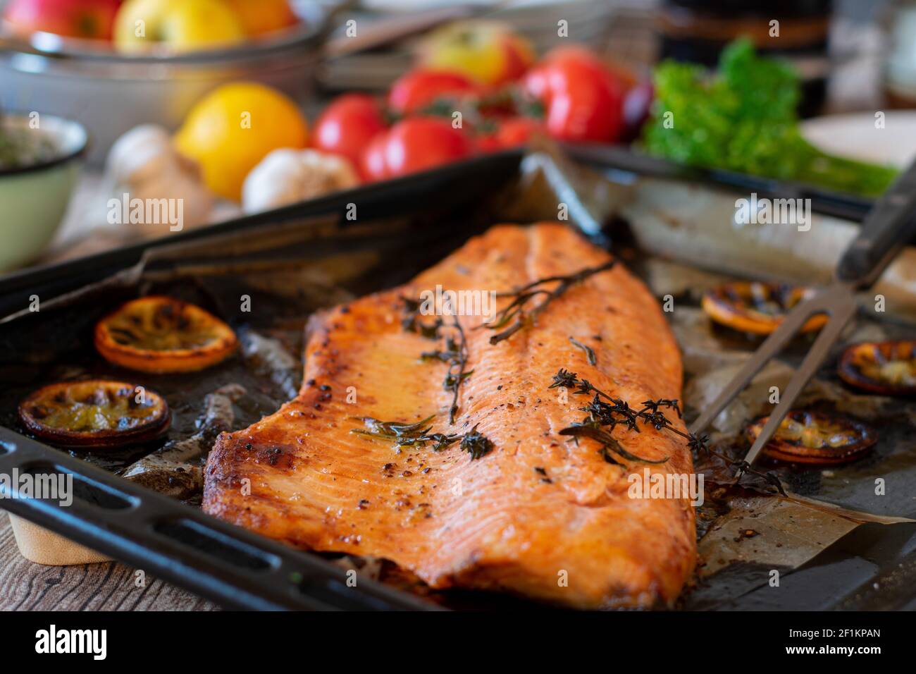 Im Ofen gebackener offener Lachs mit mediterranen Kräutern und Zitrone Scheiben auf einem Backblech heiß serviert Stockfoto