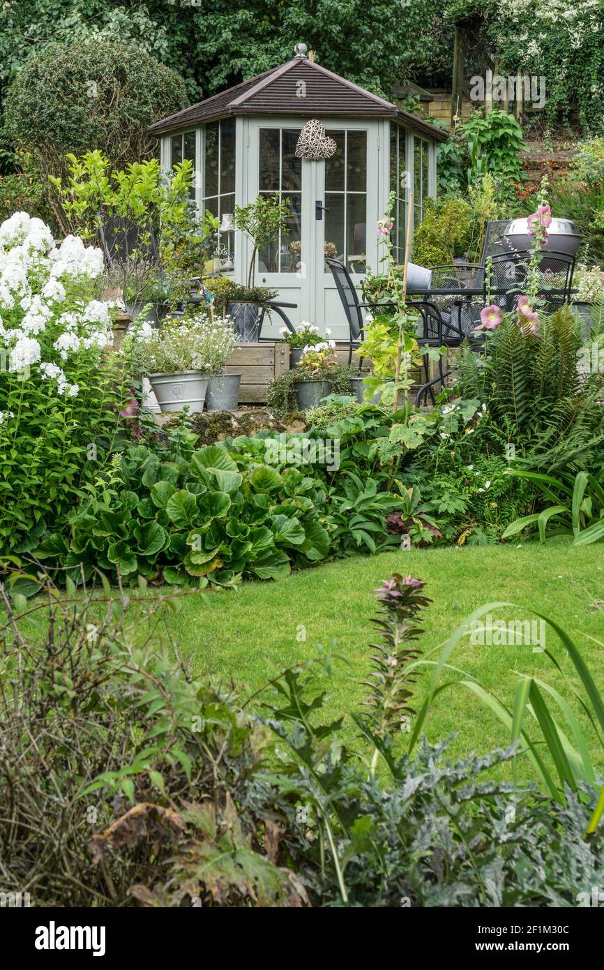 Attraktiver Garten im Sommer mit Holzgartenraum im Gutsdorf Edensor, Derbyshire, UK Stockfoto