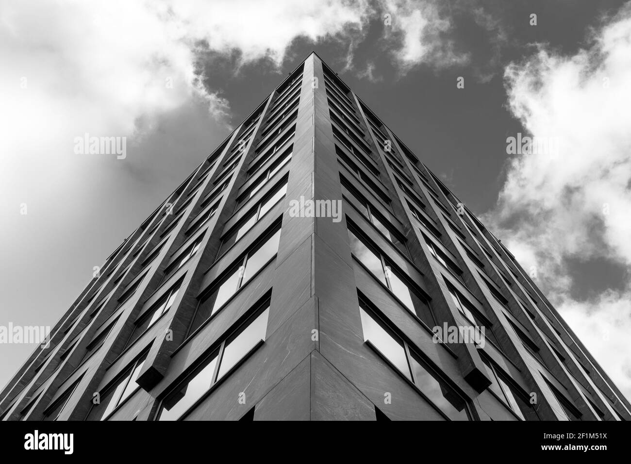 Interessante Schwarz-Weiß-Perspektive der Fassade eines Gebäudes gegen den Himmel mit Wolken. Stockfoto