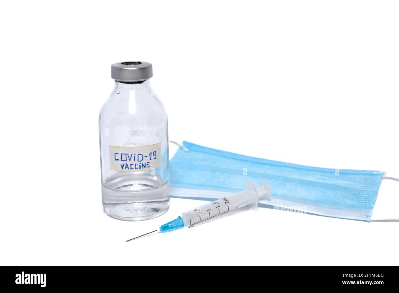 Coronavirus-Impfampulle, Einwegspritze und medizinische Gesichtsmaske isoliert auf weißem Hintergrund Stockfoto