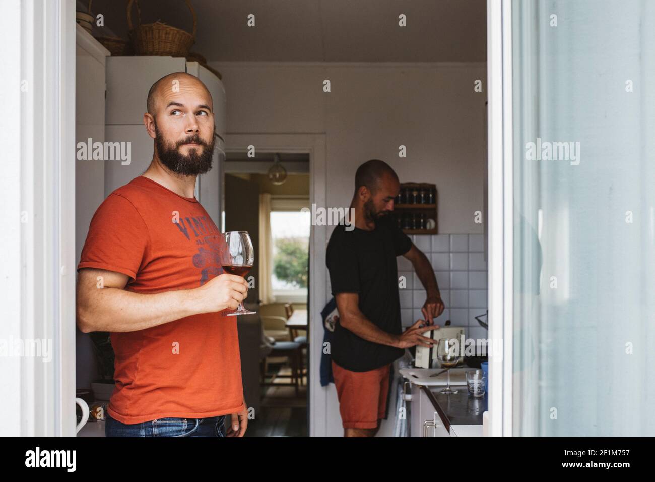 Mann hält Weinglas in der Küche Stockfoto