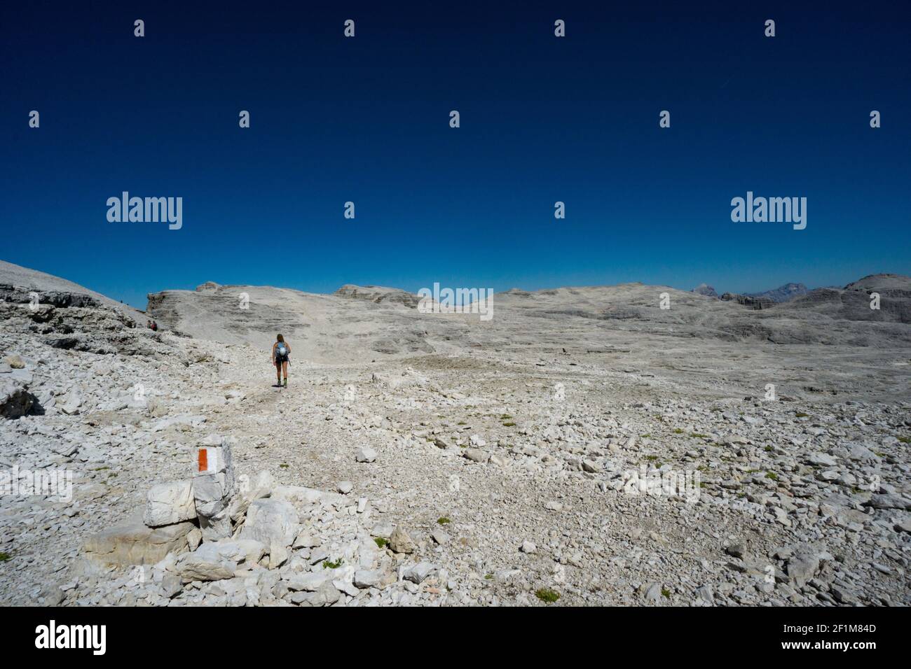 Bergsteigerinnen wandern durch eine wilde Felsenwüste hoch In den Dolomiten nach einem harten Aufstieg Stockfoto