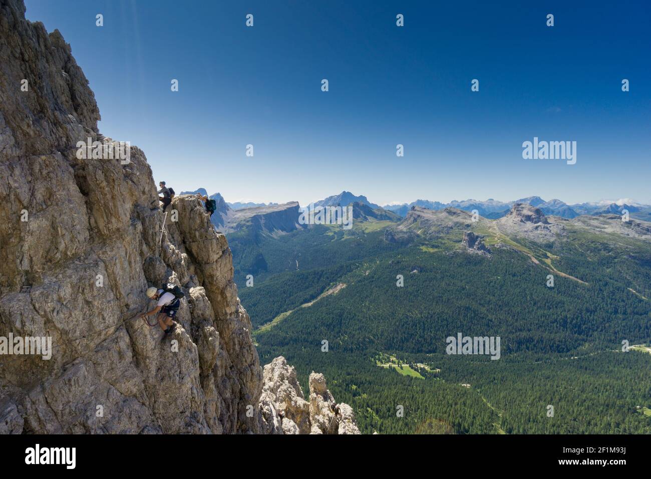 Blick auf eine Gruppe von Bergsteigern auf einem steilen Via Ferrata mit einem grandiosen Blick auf den italienischen Dol Stockfoto