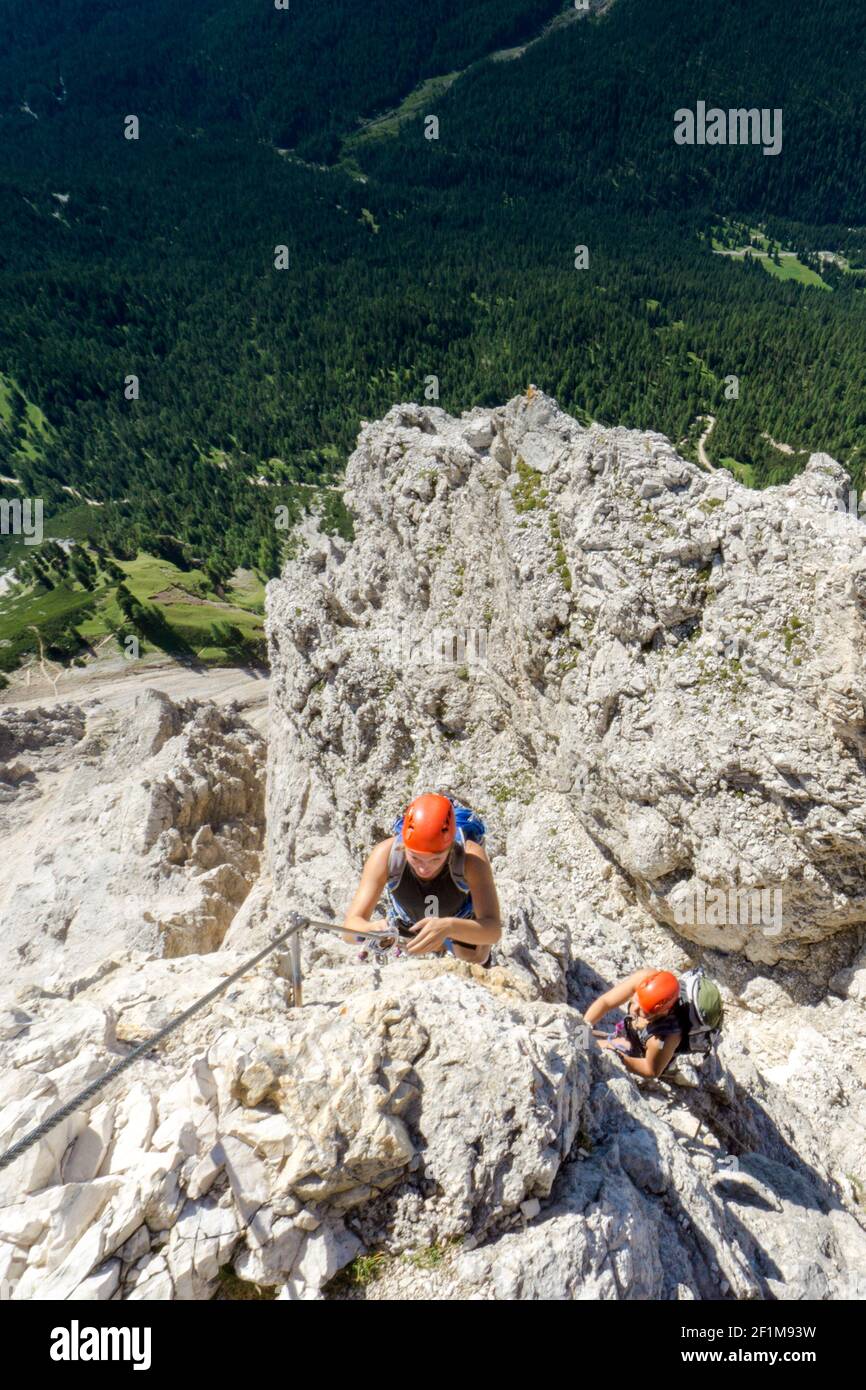 Zwei Bergsteigerinnen auf einem exponierten Klettersteig in Die Dolomiten von Italien Stockfoto