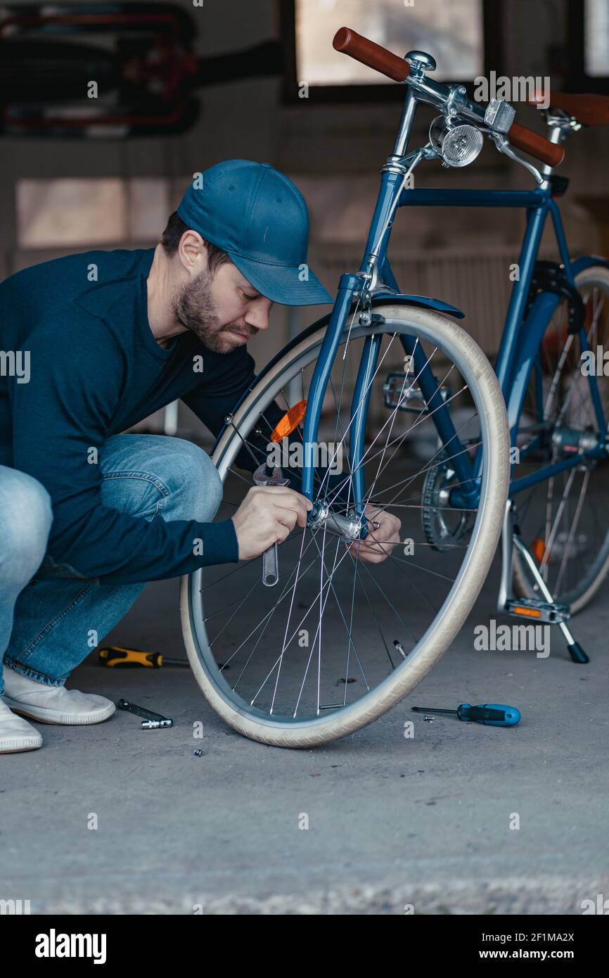 Mann repariert Fahrrad in der Garage Stockfoto