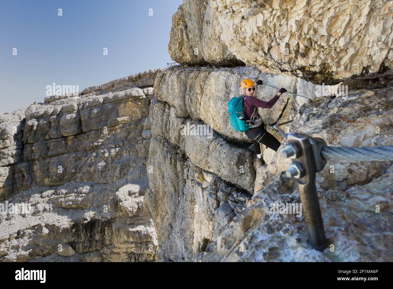 Attraktive blonde Bergsteigerin in den italienischen Dolomiten Stockfoto