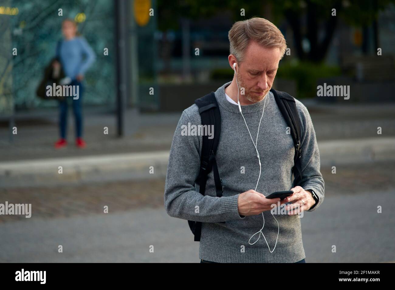 Mann auf der Straße hält Telefon Stockfoto