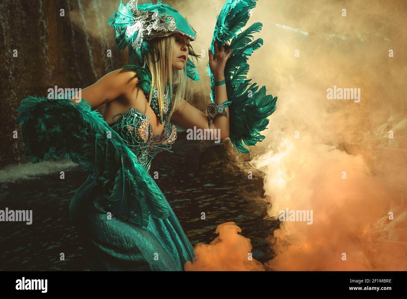 Fantasy-Szene, schöne blonde Frau in ausgefallenen Kleid und blauen Engelsflügel auf den Armen Stockfoto