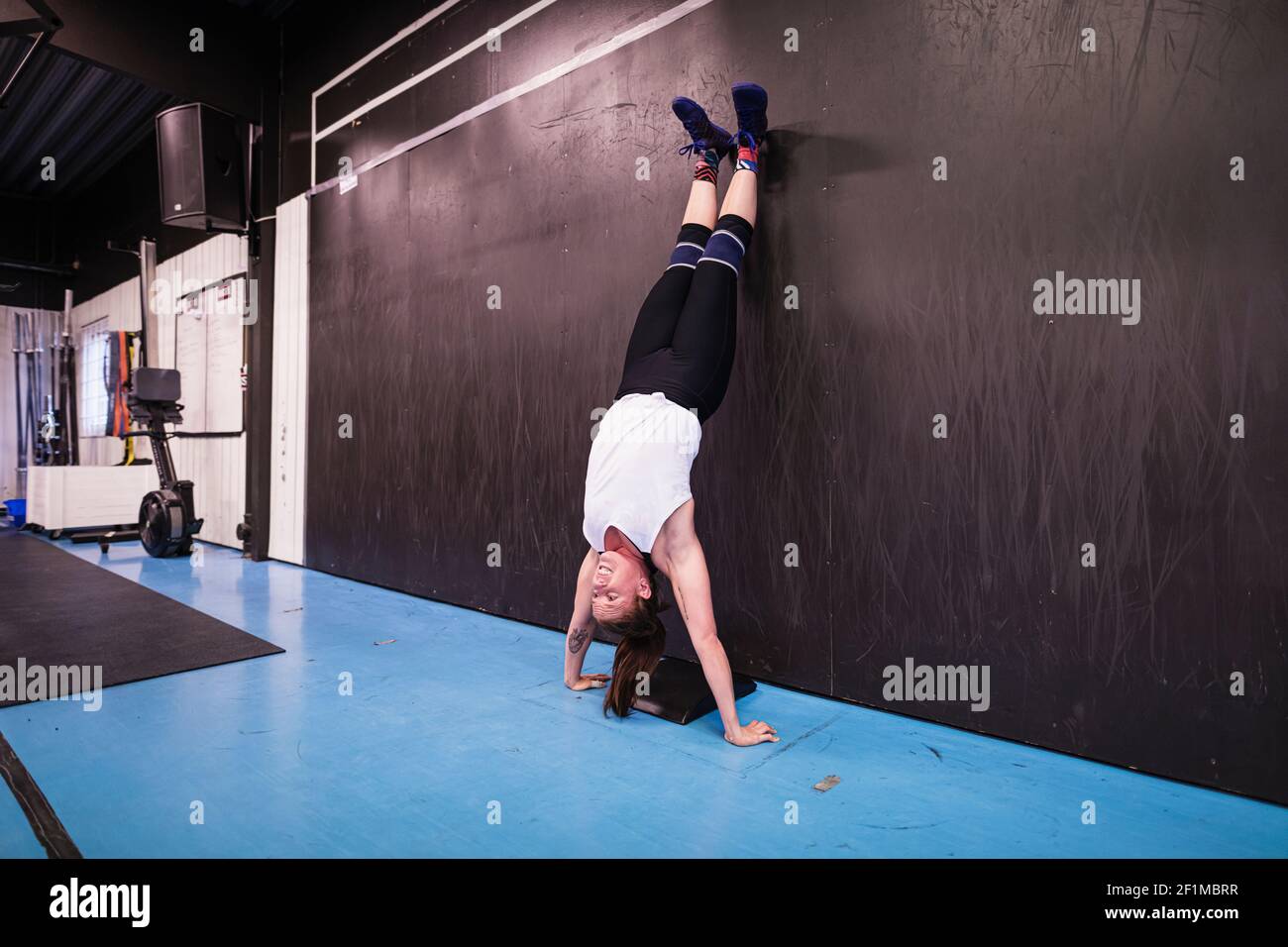 Frau im Fitnessstudio mit Handstand Stockfoto
