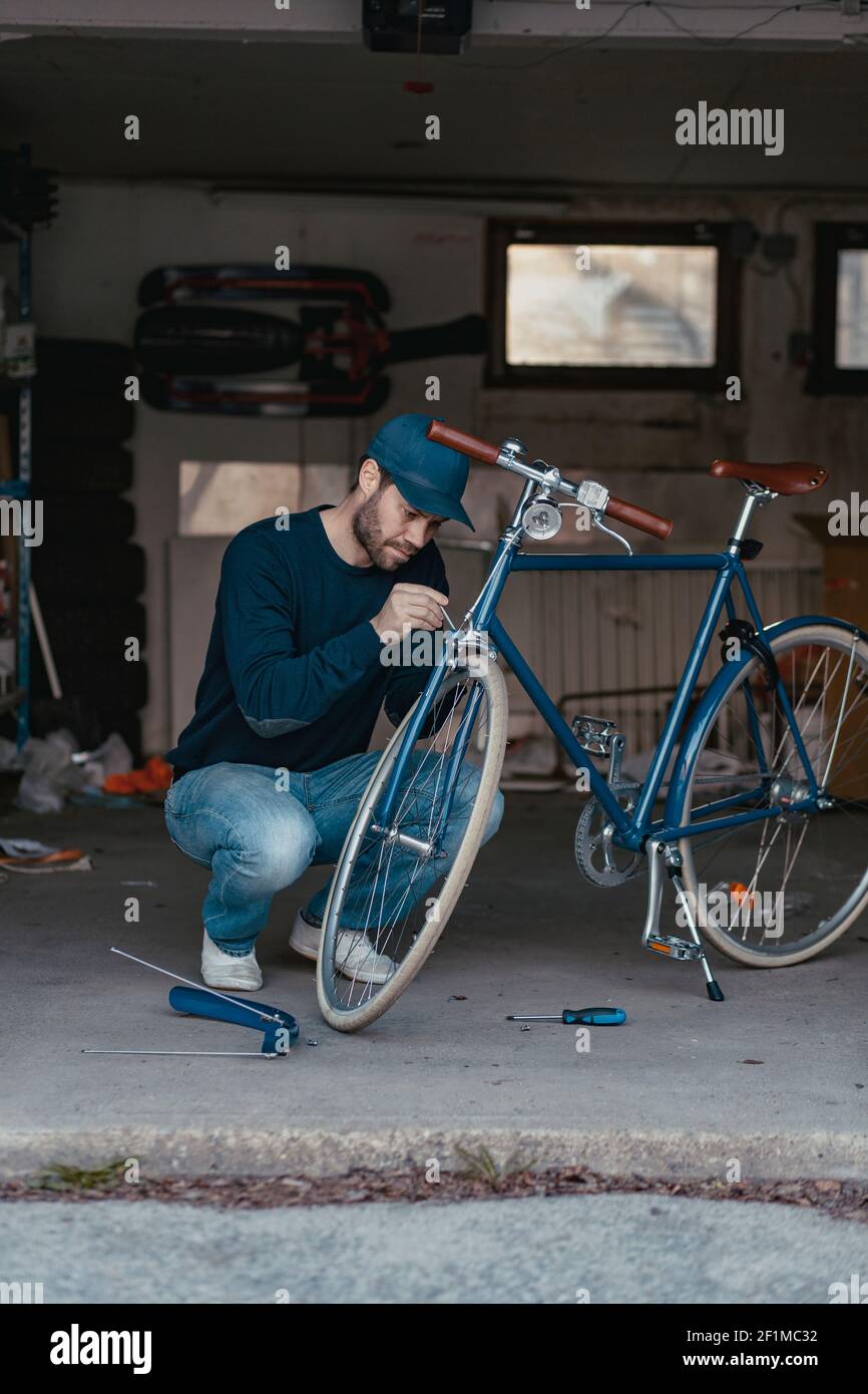 Mann repariert Fahrrad in der Garage Stockfoto