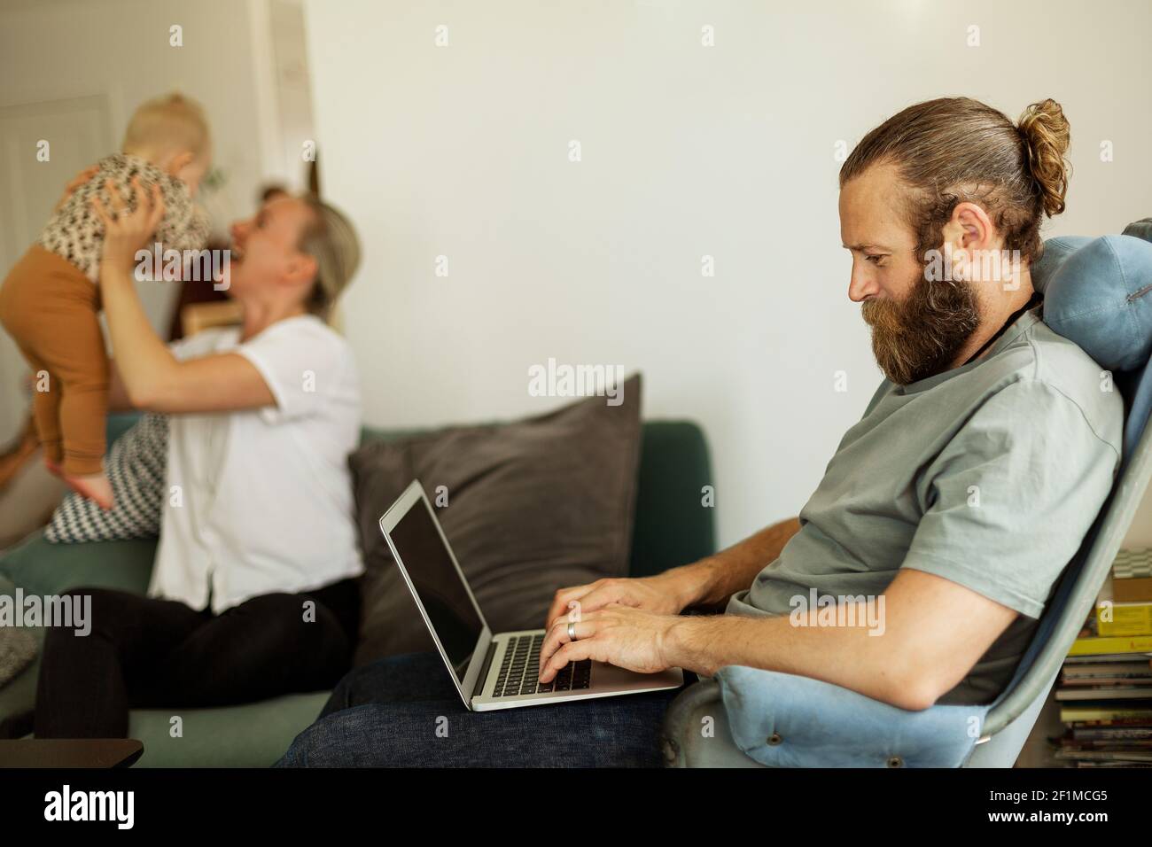 Mann auf Stuhl sitzend und mit laptop Stockfoto