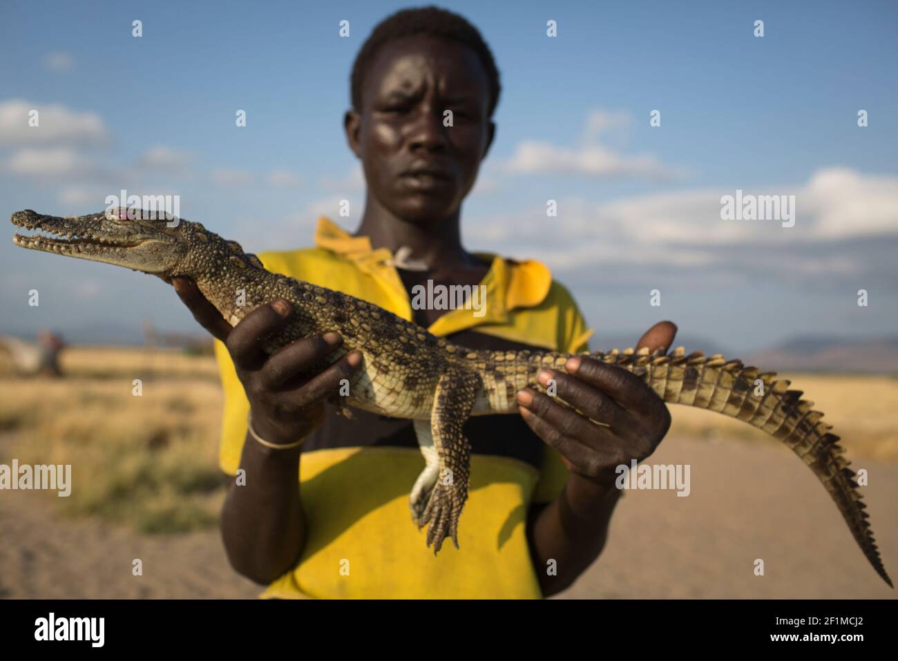 Mann mit Krokodil am Ufer des Sees Turkana, Kenia. Stockfoto
