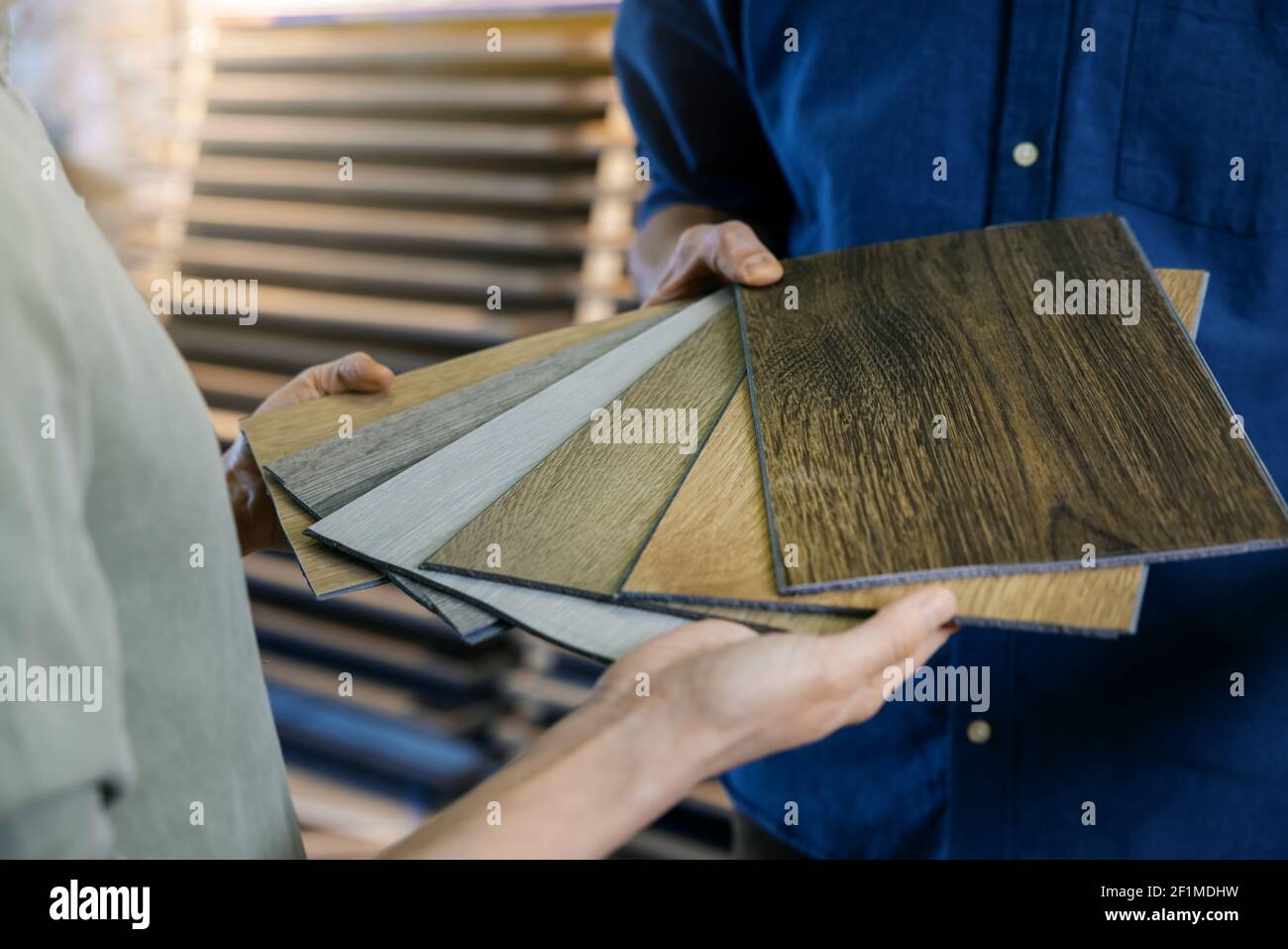 verkäufer zeigt dem Kunden Muster von Laminatmaterial mit Holzstruktur Stockfoto